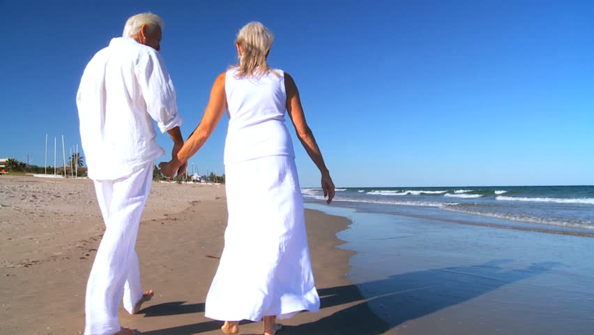 Loving Senior Couple Enjoying Retirement Leisure Walking The Beach ...