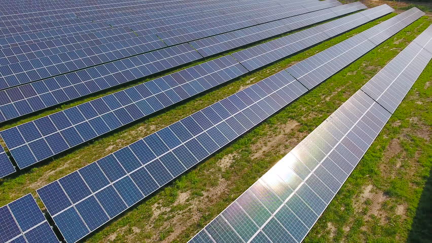 Aerial View. Flying over the solar power plant with sun. Solar panels 