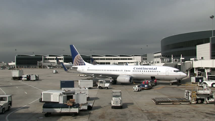 Busy Airport Ramp With Continental Aircraft Having Baggage Unloaded 