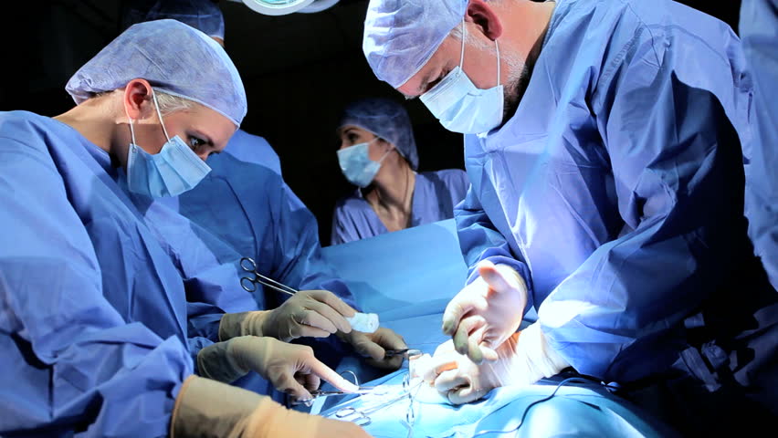 Multi Ethnic Medical Team Performing Operation In Hospital Operating ...