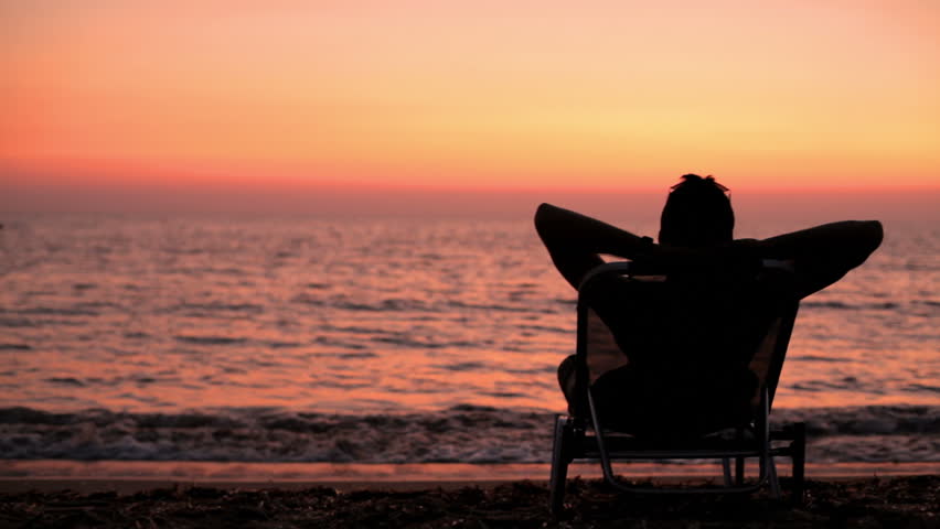 A Man Sits In Beach Chair Relaxing At Dusk Stock Footage Video 4821329