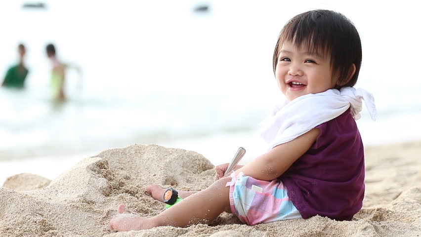Smiling Cute Asian Kid, Child, Little Girl Lay Down On The Sand Beach In Sunny Day Stock Image 