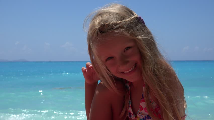 Portrait of Happy Little Girl Looking in Camera on Beach 