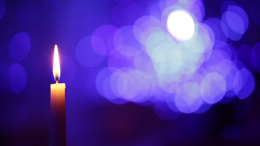 Loop features a white pillar candle with flickering flame backed by Loop features a white pillar candle with flickering flame backed by