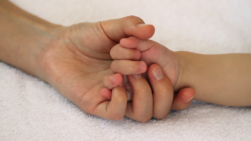 hand-in-hand-mother-and-newborn-daughter-in-maternity-hospital-stock