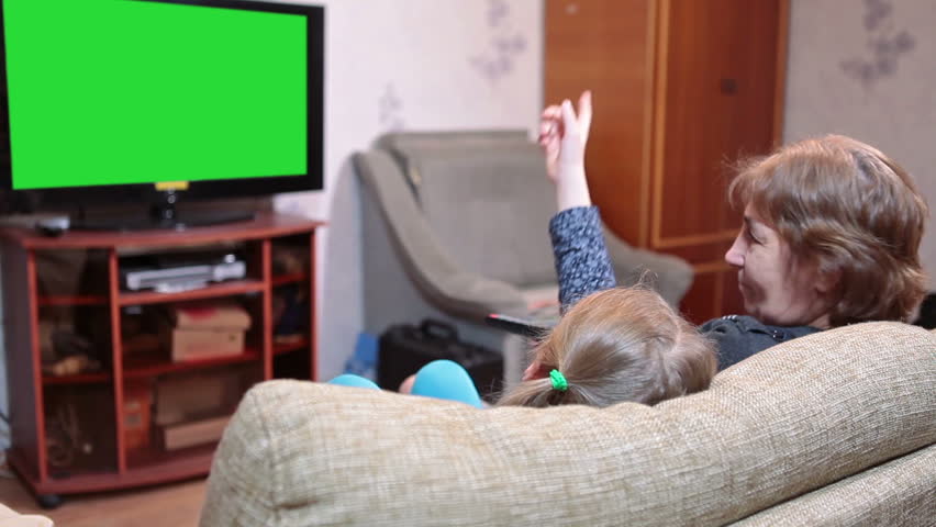 Mother And Her Daughter Watching Green Screen Tv In Living ...