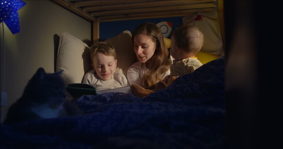 Mother And Child Reading A Book Before Bed Time Stock