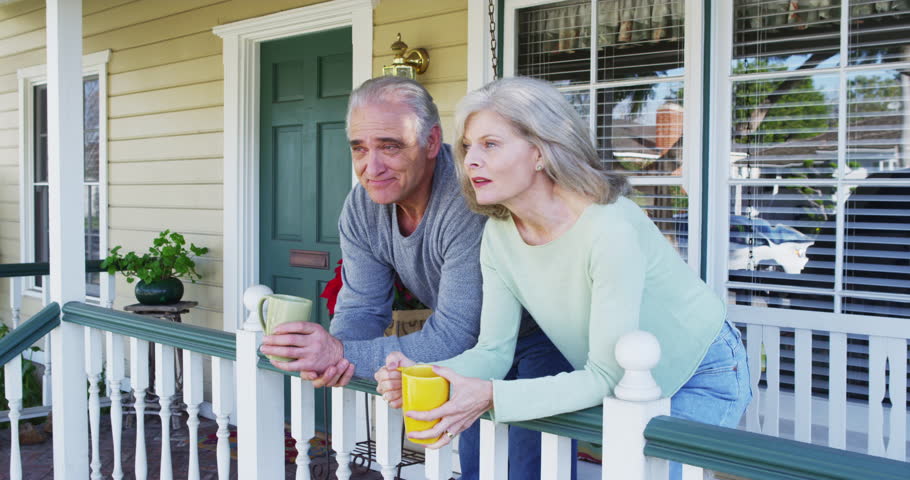 Happy Senior Couple Sitting On Porch Talking Stock Footage Video