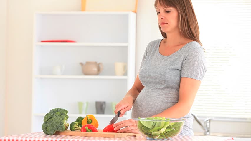 Happy Pregnant Woman Chopping Vegetables In Her Kitchen Stock Footage ...