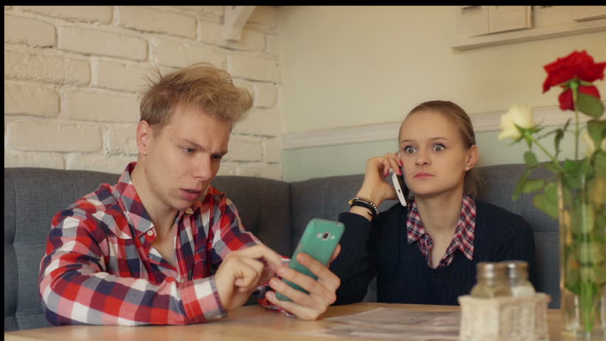 Girl Talking On Cellphone And Boy Texting Sms In The Restaurant Stock ...