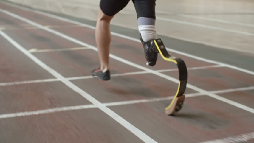 Follow Shot Of Professional Amputee Athlete With Artificial Leg Running ...