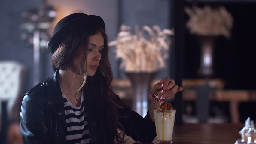 Beautiful Young Woman In Restaurant With A Glass Of Milkshake In Hand ...