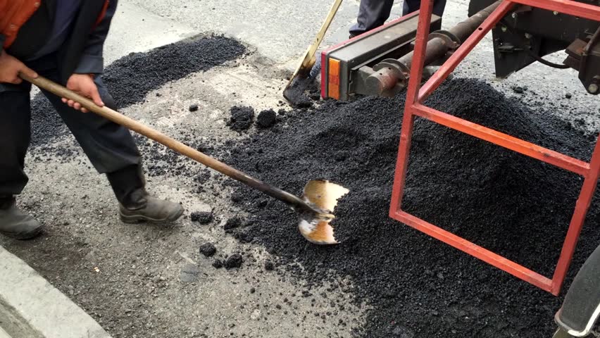 Road Works On A Road. A Machine Is Scraping The Asphalt Which Is Fed ...