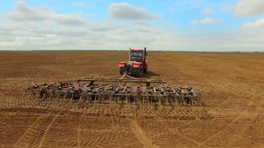 Agricultural Tractor Cultivating Field, Preparing For Sowing Stock ...