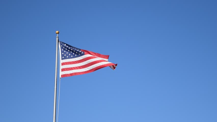 HD Large American Flag Flying In The Wind With A Jet Flying By In The ...