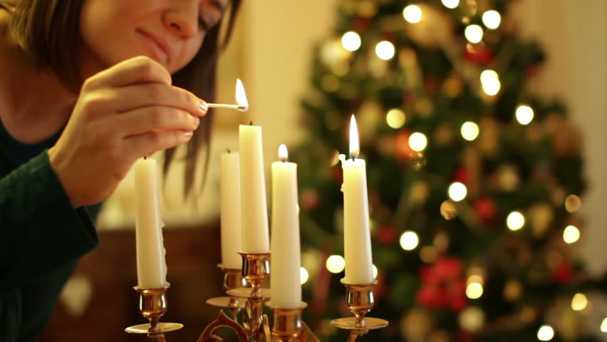 Young Woman Lighting A Candle, Christmas Tree In Background Stock ...