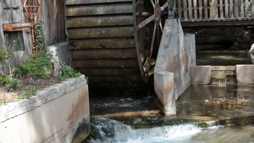 Old Antique Water Wheel Turning Against A Wood Building. Water Diverted ...