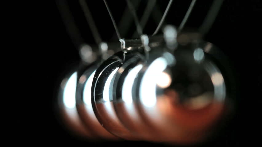 Close up of Newton's Cradle, Desk toy pendulum being activated, black ...