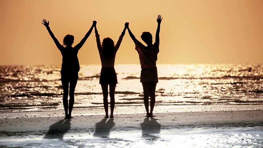 Three Girls Celebrating The End Of Day With Sunset In Silhouette Stock ...